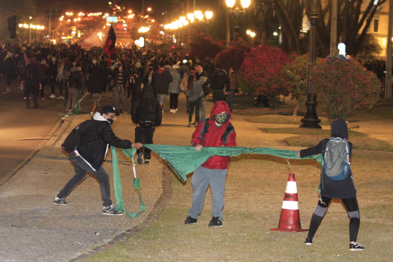 Três jovens com a bandeira do Brasil no ato em Curitiba. (Geraldo Bubniak / AGB)