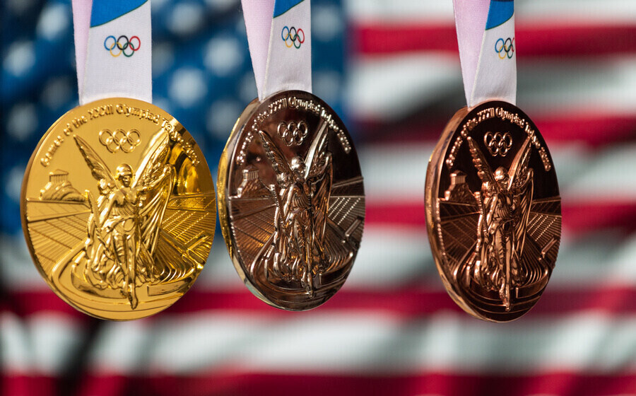 April 25, 2021 Tokyo, Japan. Gold, silver and bronze medals of the XXXII Summer Olympic Games 2020 in Tokyo on the background of the US flag.