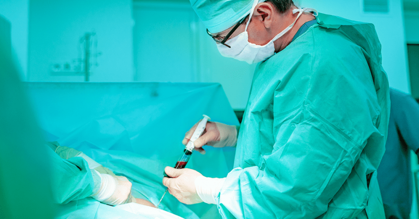 Médico em sala de cirurgia realizando um transplante de medula óssea